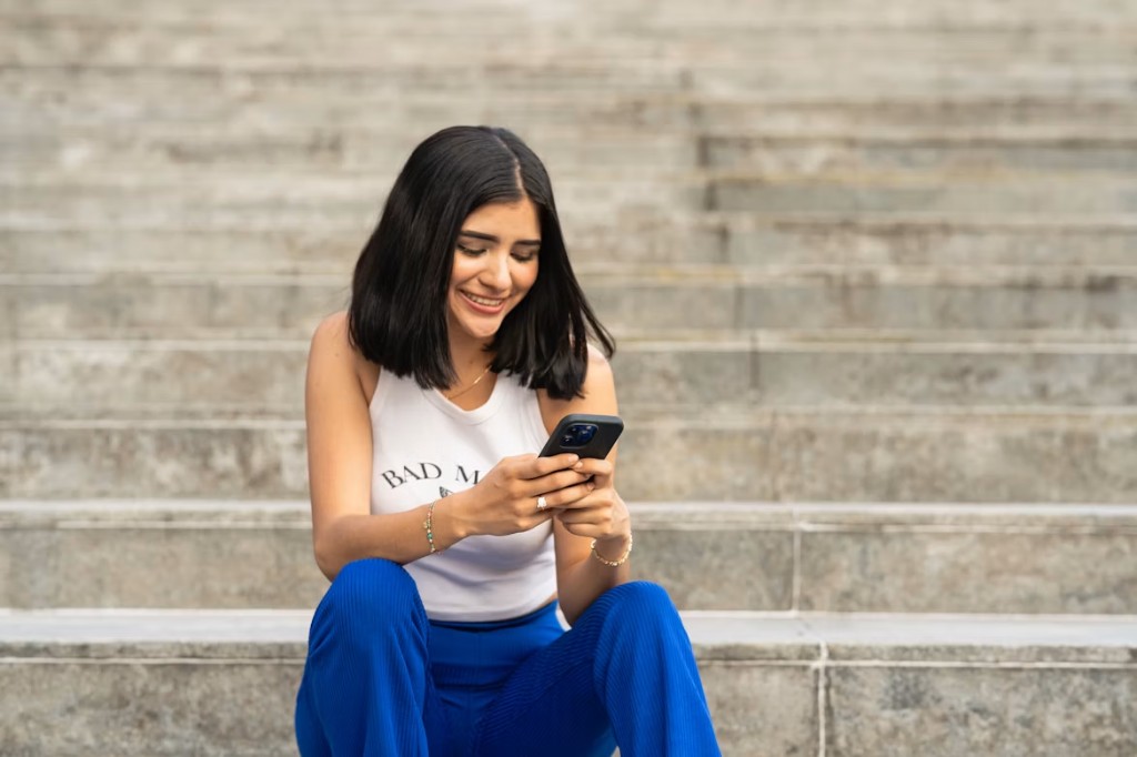 Person smiling while using the MoneyPal app on their phone