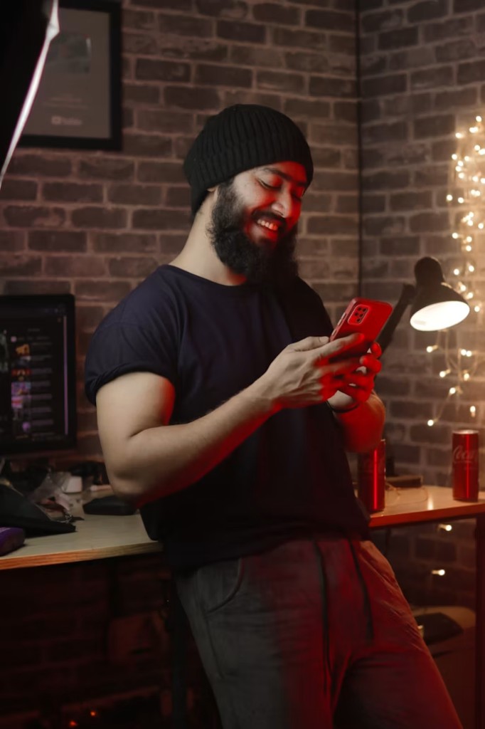 Person smiling while using the MoneyPal app on their phone at home